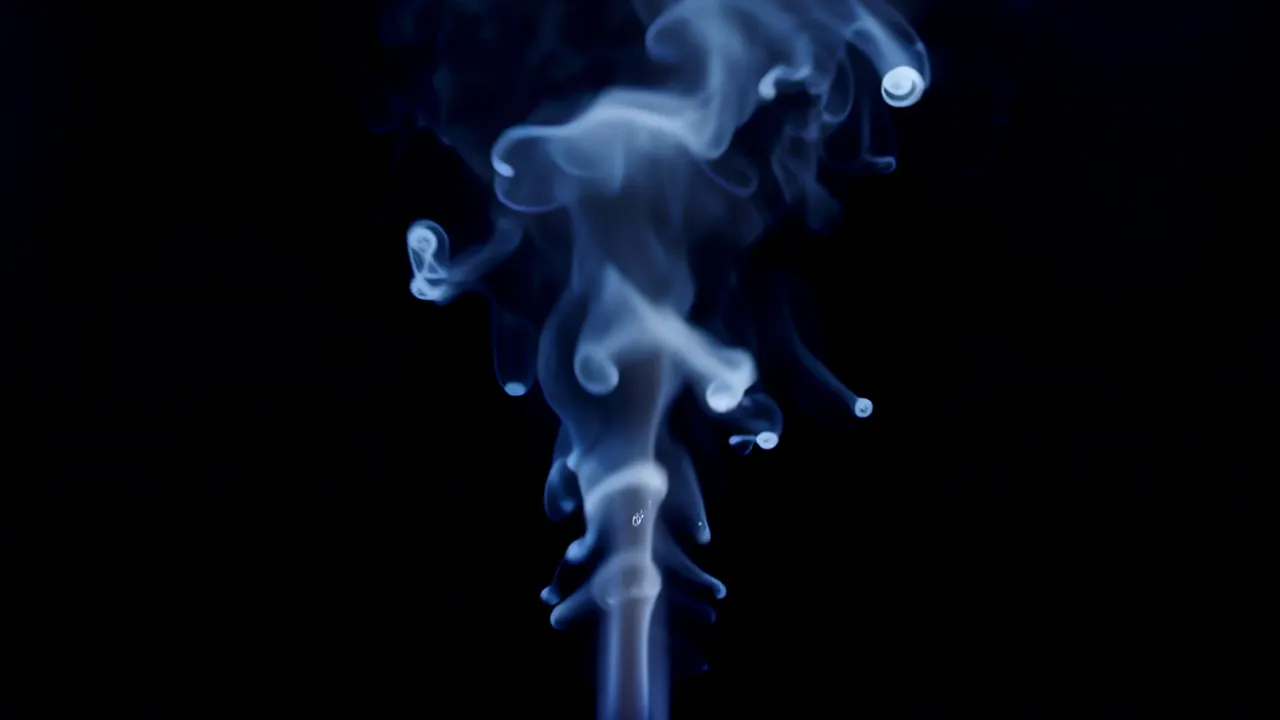 Soft White Tendrils of Steam Rising Against Black Background
